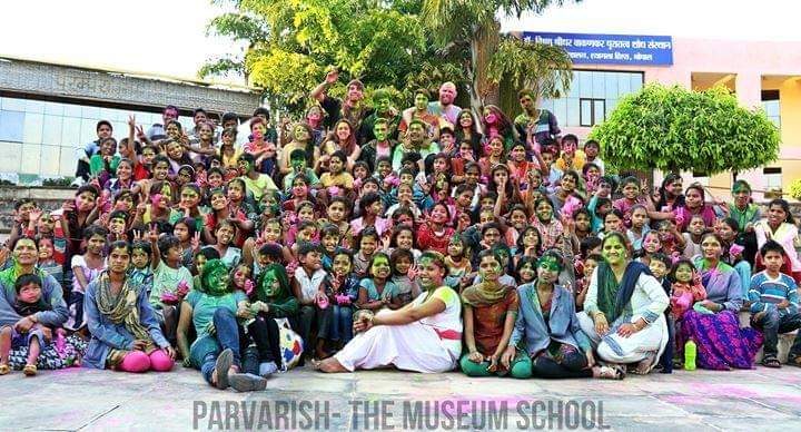 A large group photograph of Museum School children and teachers covered in colour at Holi